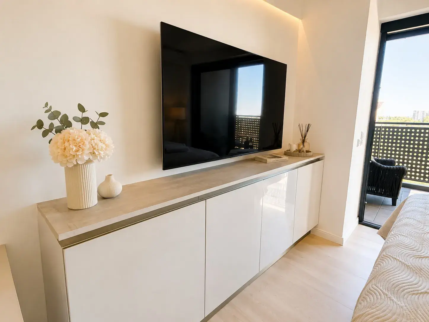 TV on a sideboard next to the balcony door